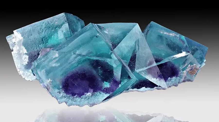 A stunning fluorite crystal specimen with vivid blue and purple hues, showcasing the natural cubic structure of this collectible mineral.