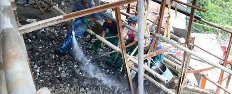 Miners washing and sorting freshly extracted tungsten ore at a mining site.